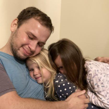 Zoltan hugging his two daughters